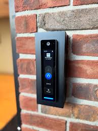 UniFi Access reader mounted beside a brick entryway